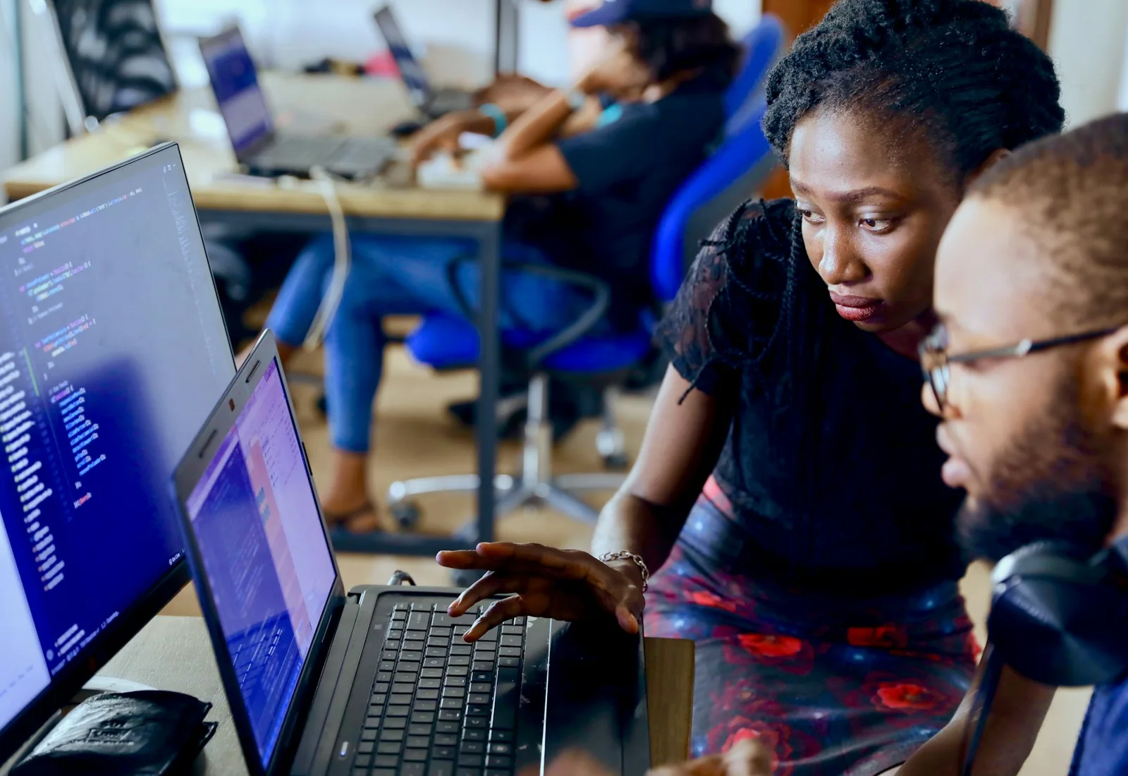 Technology professionals collaborating around a laptop in a Lagos workspace