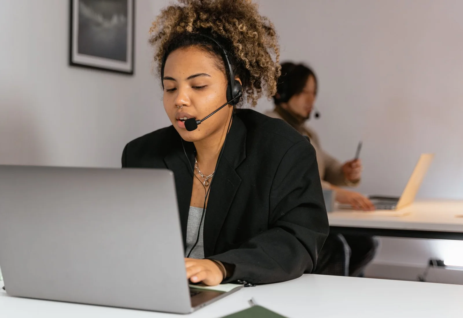 A customer-service professional responding through a headset and laptop